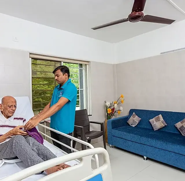 Caregiver supporting and attending to an elderly resident with warmth