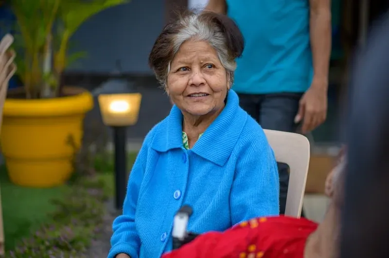 Senior lady smiling happily while receiving attentive care